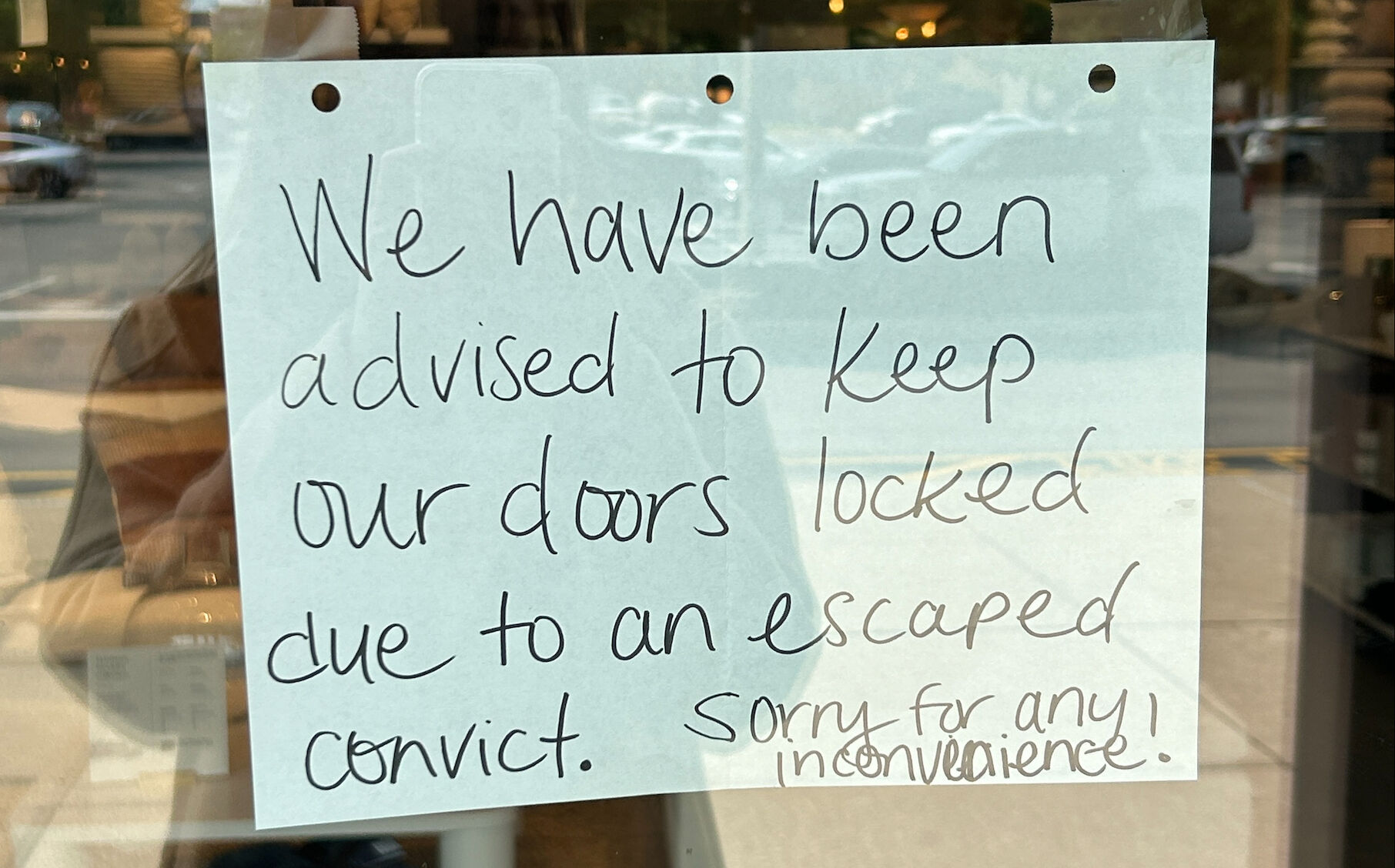 A sign on the door of a store at The Paddock Shoppes during escaped inmate search on May 18, 2023